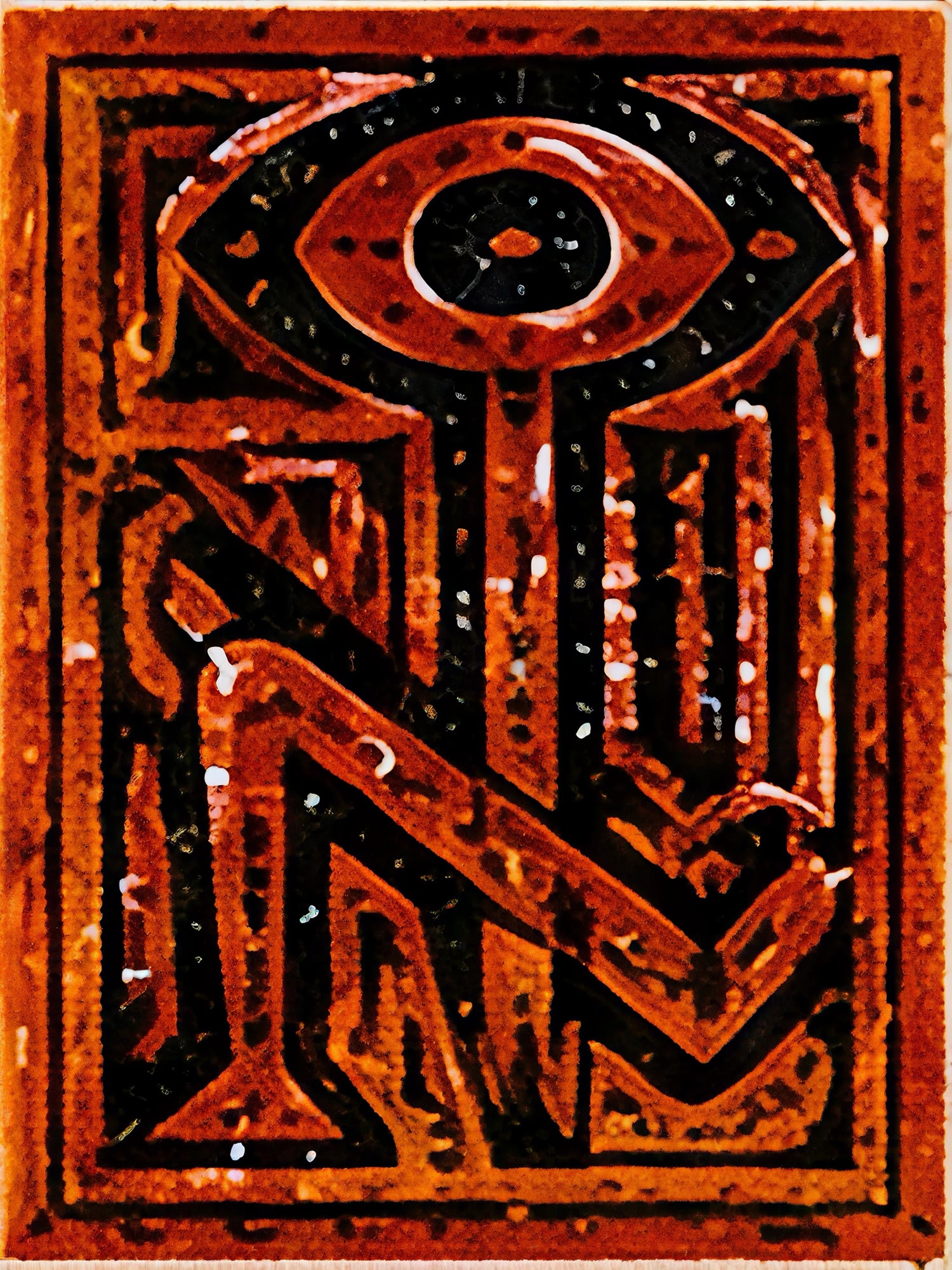 Carved glyph in burnt orange and black: an eye set on a staff that folds into a zigzag, inside a heavy border, with a speckled surface.